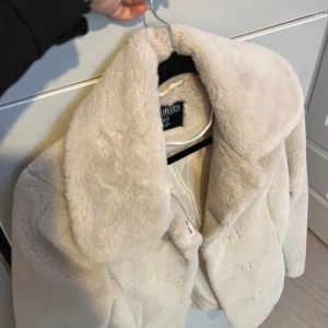Beige pälsjacka från Stories - Säljer en supermjuk och stilren beige pälsjacka från Stories. Jackan har en klassisk krage och stängs med knappar framtill. Perfekt för att hålla sig varm och snygg under kyliga dagar. 🧥✨ använd någon gång bara 