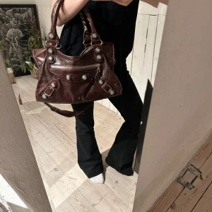 Röd/brun balenciaga väska - Säljer denna Balenciaga City bag, i medium storlek. Köptes här på plick för några veckor sen. Säljer då den inte passar mig. Tjejen jag köpte väskan av köpte den ifrån en vintage butik i Köpenhamn. Kvitto medfölljer därav inte.Väskan har serienummer i sig och många andra äkthets aspekter. Nypris är 20 000❣️