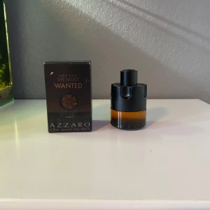 Azzaro The Most Wanted Parfum - Säljer en flaska Azzaro The Most Wanted Parfum. Flaskan har en unik design med en svart och orange färgkombination. Parfymen kommer i en elegant kartong med bronsdetaljer. Perfekt för den som vill ha en distinkt och minnesvärd doft.