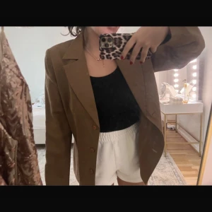 Brun kavaj - Snygg brun kavaj med klassisk design och knappar framtill. Perfekt för en stilren look. Passar bra till både vardag och mer uppklädda tillfällen. Den är i storlek 42 men passar även mig som är S (första bilden)
