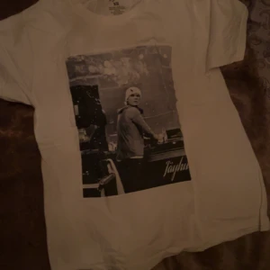 Vit t-shirt med tryck från Jayhu - Säljer en vit t-shirt från Jayhu med ett coolt svartvitt tryck på framsidan. T-shirten är kortärmad och har en normal passform. Perfekt för en avslappnad stil.