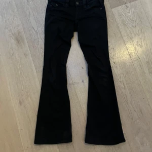 Svarta bootcut jeans från True Religion - Snygga svarta bootcut jeans från True Religion. Passar cirka 170 cm och är i bra skick! Har ni frågor är det bara fråga!