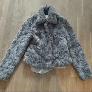 Grå pälsjacka från Vila - Säljer en supermjuk och fluffig grå pälsjacka från Vila. Jackan har en klassisk krage och långa ärmar, perfekt för kyliga dagar. Den är både stilren och mysig, vilket gör den till ett måste i garderoben. Passar perfekt för höst och vinter!