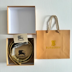 Burberry bälte - Box, dirt bag, påse, burburry kort fås med med en  Snyggt bälte från Burberry med klassiskt rutigt mönster i beige, svart och röd. Bältet har två sidor så man kan bära bältet på två olika sätt. Bältet har en stilren silverfärgad spänne med Burberrys ikoniska logotyp. Perfekt för att ge en touch av lyx till din outfit.