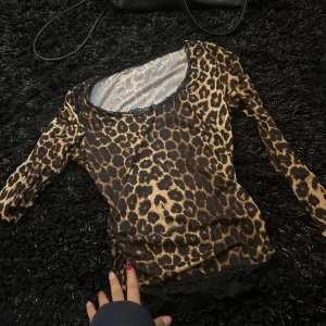Leopardmönstrad topp  - Snygg leopardmönstrad topp med långa ärmar och spetsdetaljer vid halsringningen och nederkanten. Knappt använd. 