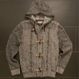 Grå stickad hoodie med träknappar - Säljer en snygg grå stickad hoodie med träknappar. Tröjan har storleken L men sitter som S/M. Skriv vid intresse eller fler bilder 