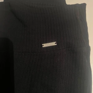 Svarta ribbade leggings från Aim'n - Snygga svarta ribbade leggings från Aim'n. Perfekta för både träning och avslappning. De har en tight passform och är tillverkade i ett stretchigt material! De är i Petit modellen (den kortare modellen) vilket jag insåg var för kort för mig och dörför är de bara använda ca 2 gånger!