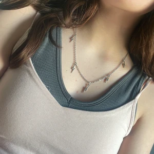 Silverhalsband med blixtberlocker - Snyggt silverhalsband med små blixtformade berlocker. Perfekt för att ge en edgy touch till din outfit. Kedjan är tunn och elegant, vilket gör det lätt att bära till olika stilar. Knappt använt💞