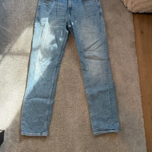 Blå jeansbyxor - Snygga blå jeansbyxor med en klassisk straight fit. De har en midwaist design och är perfekta för en avslappnad stil. Byxorna har en dragkedja och knappar framtill