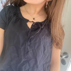 Svart blus med knytband - Jätte söt svart/mörkblå blus perfekt till sommaren. Sitter lite stort på mig som vanligtvis har storlek xs❣️(strå att de är storlek 38)