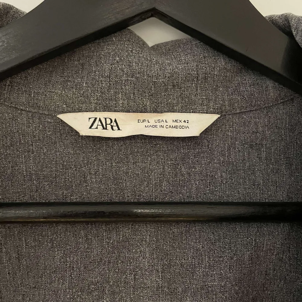 Snygg grå jacka från Zara i en stilren design. Perfekt för lager-på-lager och har en klassisk krage. Passar bra till både vardag och mer avslappnade tillfällen.. Takit.