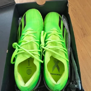 Adidas X Speedportal inomhus neon - Säljer ett par Adidas X Speedportal fotbollsskor inomhus i neon-grönt med svarta detaljer och gula inslag. Skorna har snörning och är tillverkade i syntetmaterial med ventilerande mesh. Perfekta för dig som vill sticka ut på planen med riktigt snabb känsla.