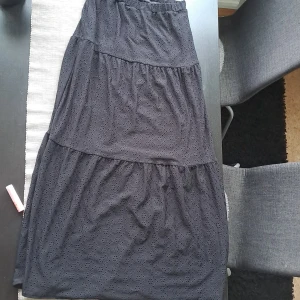 Svart långkjol med broderade detaljer - BARN STORLEK 146/152Svart långkjol från Kappahl med broderade hålmönster och volanger. Kjolen har en luftig och flowy känsla, perfekt för dig som gillar en avslappnad men ändå stilren look. Resår i midjan för extra komfort.