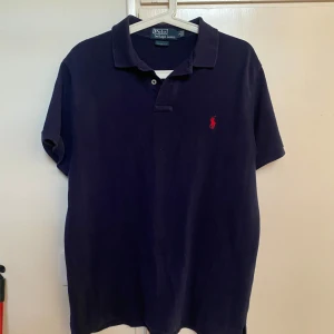 Mörkblå Polo Ralph Lauren pike  - Mörkblå polo Ralph lauren pike. Storlek L i slim fit. Använd fåtal gånger och är i fint skick!