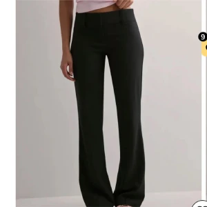 Low waist bootcut kostymbyxor - Snygga svarta kostymbyxor från Nelly i storlek 42. Byxorna är lågmidjade och utsvängda. Typiskt ”kostym” material. Helt nya, aldrig använda men finns ingen prislapp på.