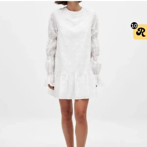 Vit blommig klänning från NA-KD❤️ - Superfin vit kortklänning med blommigt broderi och volang nertill. Klänningen har långa, lätt puffiga ärmar med volang vid ärmslut och rund halsringning. Perfekt för sommarens alla tillfällen och ger en romantisk vibe.