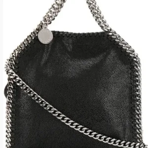 Svart Stella McCartney, falabella tiny tote  - Säljer en svart väska från Stella McCartney. Bra skick, kom med prisförslag😻 Finns även en axelrämskedja på som jag på bilden bara stoppat i väskan.