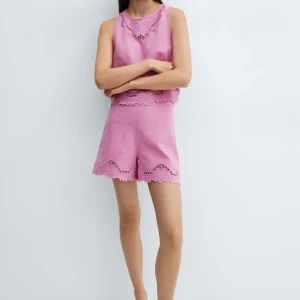 Rosa shorts med spetsdetaljer - Superfina rosa shorts med prislapp kvar, aldrig använda,  med broderade spetsdetaljer och blommigt mönster längs bensluten. De har en avslappnad passform, perfekta för varma sommardagar. Snyggt och trendigt plagg som sticker ut med sina unika detaljer.