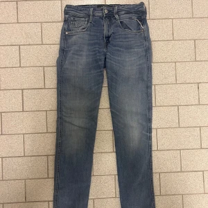 Replay anbass jeans (billiga) - Otroligt stilliga replay anbass jeans i storlek 29/34. (Defekter där av priset se de sista två bilderna). Defekt 1, liten vit slitning vid gylfen längs ned. Defekt 2, lappen av.
