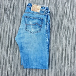 Jacob Cohen  - Klassiska Jacob Cohen jeans i ljusblå tvätt med snyggt slitna detaljer. Rak passform och femficksmodell med ikonisk läderpatch bak i midjan. Perfekta till sneakers eller boots för en avslappnad look. !AI BESKRVINING! Om ni vill ha fler bilder eller om ni har andra funderingar och frågor skriv.