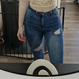 Blå ripped highwaist jeans från SHEIN - Snygga blå jeans från SHEIN med hög midja och slitna detaljer på benen och vid benslut. Modellen är slim och sitter tajt över höften. Klassisk femficksdesign och stretchigt jeanstyg som ger en bekväm passform.