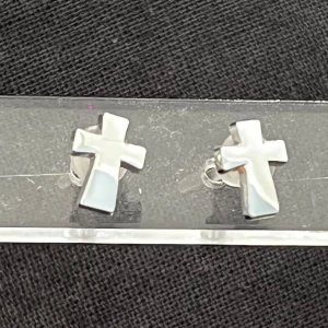 Silvriga korsörhängen - Snygga örhängen i form av kors i blankt silverfärgat material. Perfekta för dig som gillar stilrena accessoarer med en edgy touch. Små och diskreta men ändå ett statement.