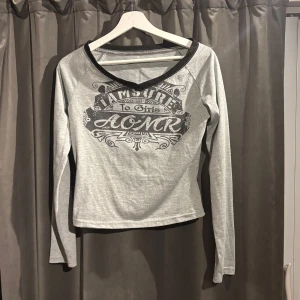 Grå långärmad topp med tryck - Säljer en grå långärmad topp med ett coolt tryck framtill. Toppen är i strl m men jag skulle säga att den passar bättre som s. Skriv gärna om eventuella frågor.🌺