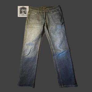 Blå jeans från Jack & Jones - 👖Snygga mörkblå jeans från Jack & Jones med en klassisk straight fit. Perfekta för en avslappnad stil. Dessa jeans är i utmärkt skick, knappt använda och har passformen Regular/Clark. Inga defekter.👖