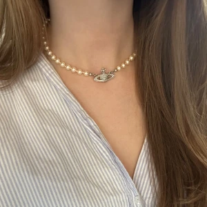 Pärlhalsband Vivienne Westwood - Ett pärlhalsband från Vivienne Westwood i silver. En av stenarna har lossnat, men syns knappt. Sparsamt använd och lådan tillkommer. 