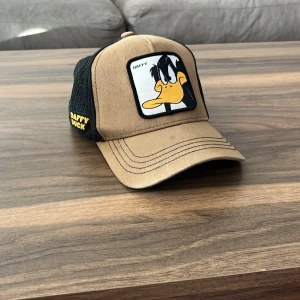  keps  - Grön/brun keps med daffy duck motiv