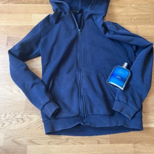 Mörkblå hoodie från Only & Sons - Säljer en mörkblå hoodie från Only & Sons med dragkedja och huva. Tröjan har långa ärmar och är fodrad med mjukt material på insidan för extra komfort. Perfekt för kyliga dagar!