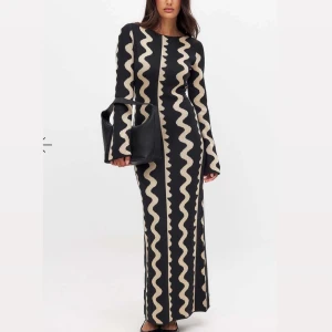 NA-KD klänning - Elegant långklänning i svart med ett vågigt beige mönster. Klänningen är köpt från NA-KD och är i st M men passar S också, det beror på din kroppsform och midjemått skulle jag säga!💗 Använt ca 2 gånger och är i ett perfekt skick! Köptes för 799kr därför sänker jag ej priset!💗💗