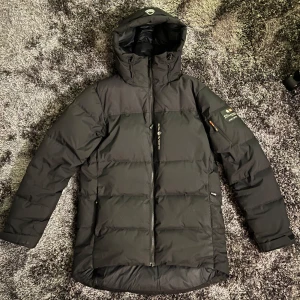 Sail Racing Cape Down Jacket - Säljer en Cape Down vinterjacka i bra skick. Jackan har två sidofickor, en innerficka och en liten ficka på vänstra armen. Använd ett fåtal gånger och värmer suveränt bra, en perfekt vinterjacka för en kall vinter. Storlek S, men passar som en M. Priset kan sänkas vid snabb affär.