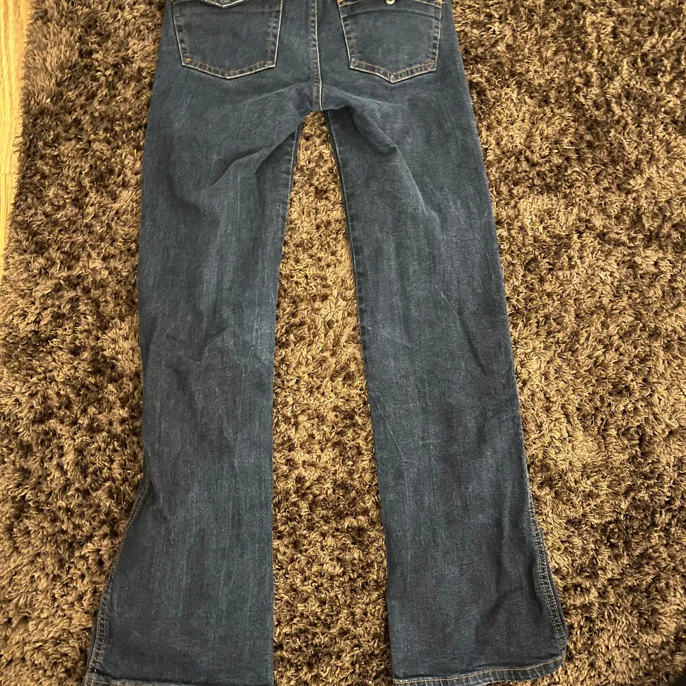 Snygga blå stockholm stil bootcut jeans med snygga hål på framsidan. Perfekta nu för våren.. De har en klassisk femficksdesign och en bekväm passform. Säljer pågrund av att dom ej kommer till andvändning längre💗. Farkut & Housut.