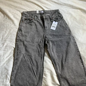 Grå jeansbyxor från Grunt - Snygga grå jeansbyxor från Grunt i modellen Street Loose. Byxorna har en lös passform och är perfekta för en avslappnad stil. De har klassiska femficksdetaljer och bälteshällor.