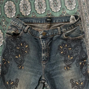 Y2k jeans🫶🏻 - Så himla snygga ”urtvättade” jeans, med snyggt broderat mönster på framsidan och även längst ner på benen, skulle säga att det är en midrise midja och flare på benen