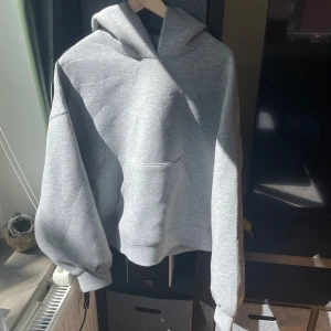 Grå hoodie från Weekday, storlek S - Bästsäljare från Weekdays hemsida! Säljer en stilren grå hoodie från Weekday i storlek S. Hoodien har en oversized passform, stor huva och en klassisk magficka. Nytt skick!