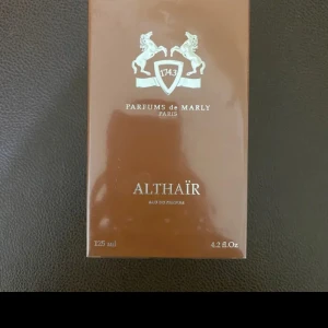Parfums de Marly Althaïr EdP 125ml - Exklusiv parfym från Parfums de Marly, Althaïr Eau de Parfum i en snygg mattbrun flaska med guldigt lock. Flaskan har en elegant relief med två hästar och märkets logga. Rymmer 125 ml och kommer i matchande brun kartong. Har inte användes en enda gång.