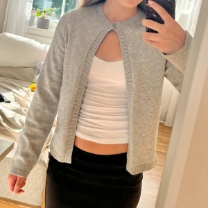 Grå kofta - Säljer denna fina grå koftan med en knapp upptill. Koftan har vida ärmar och är i nyskick. Jag köpte den på Gina för 400kr💗🥰