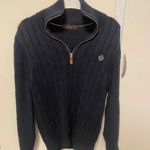 Svart stickad tröja från Morris - Svart stickad tröja från Morris med kabelstickat mönster med halfzip. Strl S, bra skick