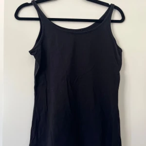 Svart linne - Ett basic svart linne med smala axelband och rundad halsringning.