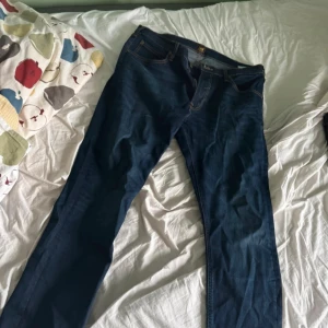 Mörkblå Lee Luke jeans W36 L32 - Säljer ett par mörkblå Lee Luke jeans i klassisk rak modell. Jeansen har snygga kontrastsömmar, fem fickor och Lee-läderpatch bak. Tillverkade i bomull med en stilren look som passar till det mesta.