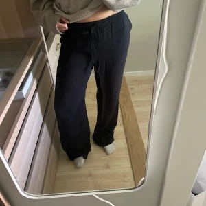 Svarta vida linnebyxor med snörning - Säljer ett par svarta linne liknande byxor med breda ben och skön passform. Pris går att diskutera💕