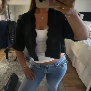 Svart croppad bolero  - Säljer min jätte fina bolero. Trekvarts ärmad och cropped med volang detaljer. Storlek L men sitter bra på mig som vanligtvis har Xs/S. Prislapp kvar. 