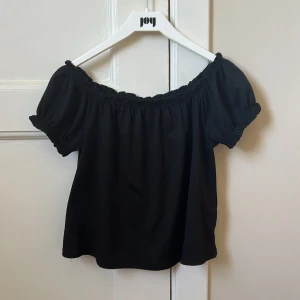 Svart offshoulder topp   - Säljer denna fina blus från Gina Tricot då den tyvärr har blivit för liten för mig. Toppen har korta puffärmar med resår och en rynkad kant upptill som ger en väldigt söt look. Skriv privat för fler bilder och eventuella frågor💞