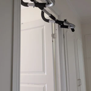Iron Gym® Xtreme Plus, Adjustable - Optimera din träning med Iron Gym® Xtreme Plus, Adjustable – den justerbara och multifunktionella träningsstången för en kraftfull överkropp. Designad för den aktiva atleten erbjuder den mångsidiga övnings- och greppmöjligheter, och passar perfekt även till bredare och djupare dörrkarmar. Oavsett om det är pull-ups, chin-ups, sit-ups eller olika arm- och skulderövningar, ger denna stång dig verktygen för att bygga styrka och muskler på ett effektivt sätt.