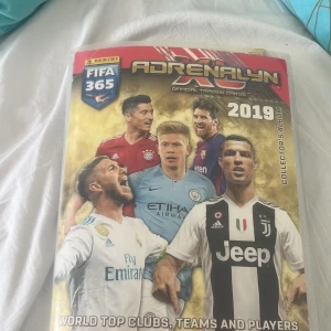 FIFA 365 Adrenalyn XL Official Trading Cards 2019 Collector's Album - Samlaralbum med FIFA 365 Adrenalyn XL 2019! Fylld med officiella fotbollskort från världens toppklubbar och spelare. Perfekt för dig som älskar fotboll, samlar på kort och vill utmana vänner i spännande matcher. En grym bok för unga sportfans och samlare!Det finns många mer sidor