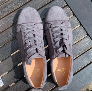 Gråa Christian Louboutin Sneakers - Säljer nu dessa snygga Christian Louboutin mocha sneakers i storlek 44 eftersom de nu tyvärr  blivit för små, skick 8/10 då skorna är använda och har lite slitage på sulorna samt ett litet hål vid hälen men det är ingenting som man lägger märke till. Lådan, alla  original papper, en sidenväska eller så kallad ”travelbag” samt ett kort med äkthetsbevis medkommer vid köp. Det är bara att höra av er vid eventuella frågor eller funderingar 😁💫