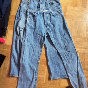 Weekday, galaxy och space 34/32 - Två par klassiska blå jeans med rak passform och femficksdesign. De har hög midja och är tillverkade i robust denim. Perfekta för en avslappnad och tidlös look.