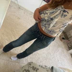 Lågmidjade pepe jeans💕 - Säljer ett par blå jeans från Pepe jeans med snygg tvätt och markerade sömmar. Byxorna har stora, rundade framfickor och klassisk dragkedja. Modellen är lowwaist och har en rak passform som sitter skönt. Perfekta för dig som gillar jeans med lite edge.